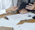 Consultores a analisar documentos sobre as novas regras do ajuste direto em contratação pública