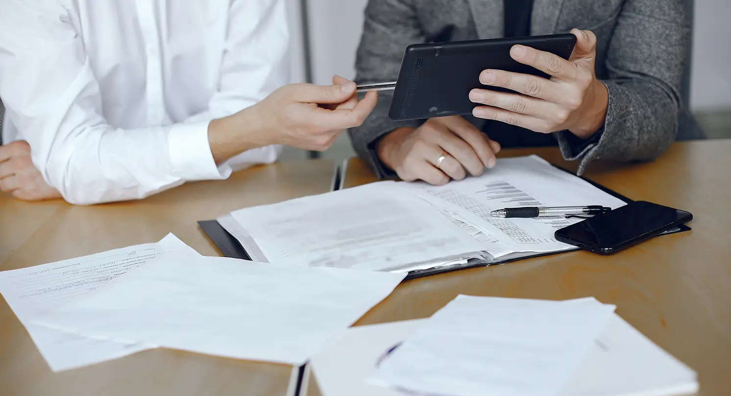 Consultores a analisar documentos sobre as novas regras do ajuste direto em contratação pública